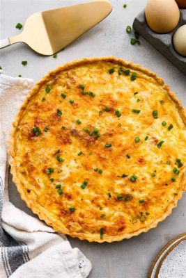  Quiche Lorraine: Eine deftige Leckerei aus dem Herzen Lothringens!  Genießen Sie die cremige Füllung dieser herzhaften Tarte mit knusprigem, goldbraunem Mürbeteig und schmelzendem Käse!